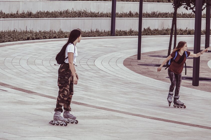 two girls skating on a circled road